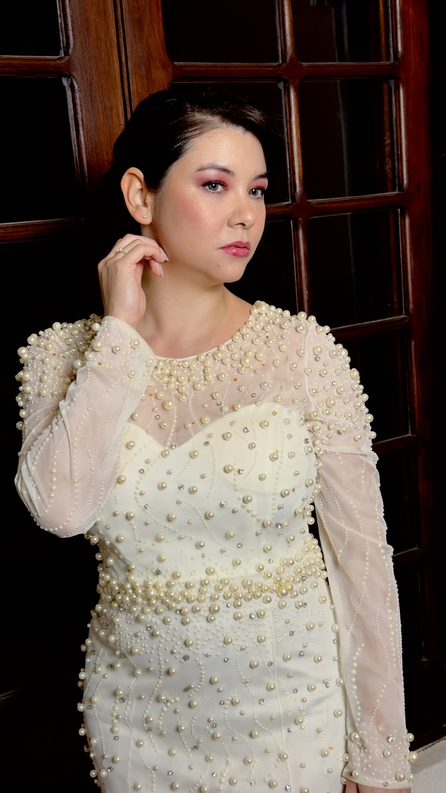 Noiva com vestido bordado de pérolas, coque baixo e maquiagem em tons neutros