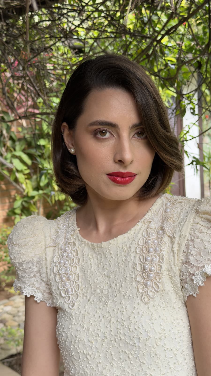 Retrato da noiva no jardim, boca vermelha e ondas marcadas no cabelo curto