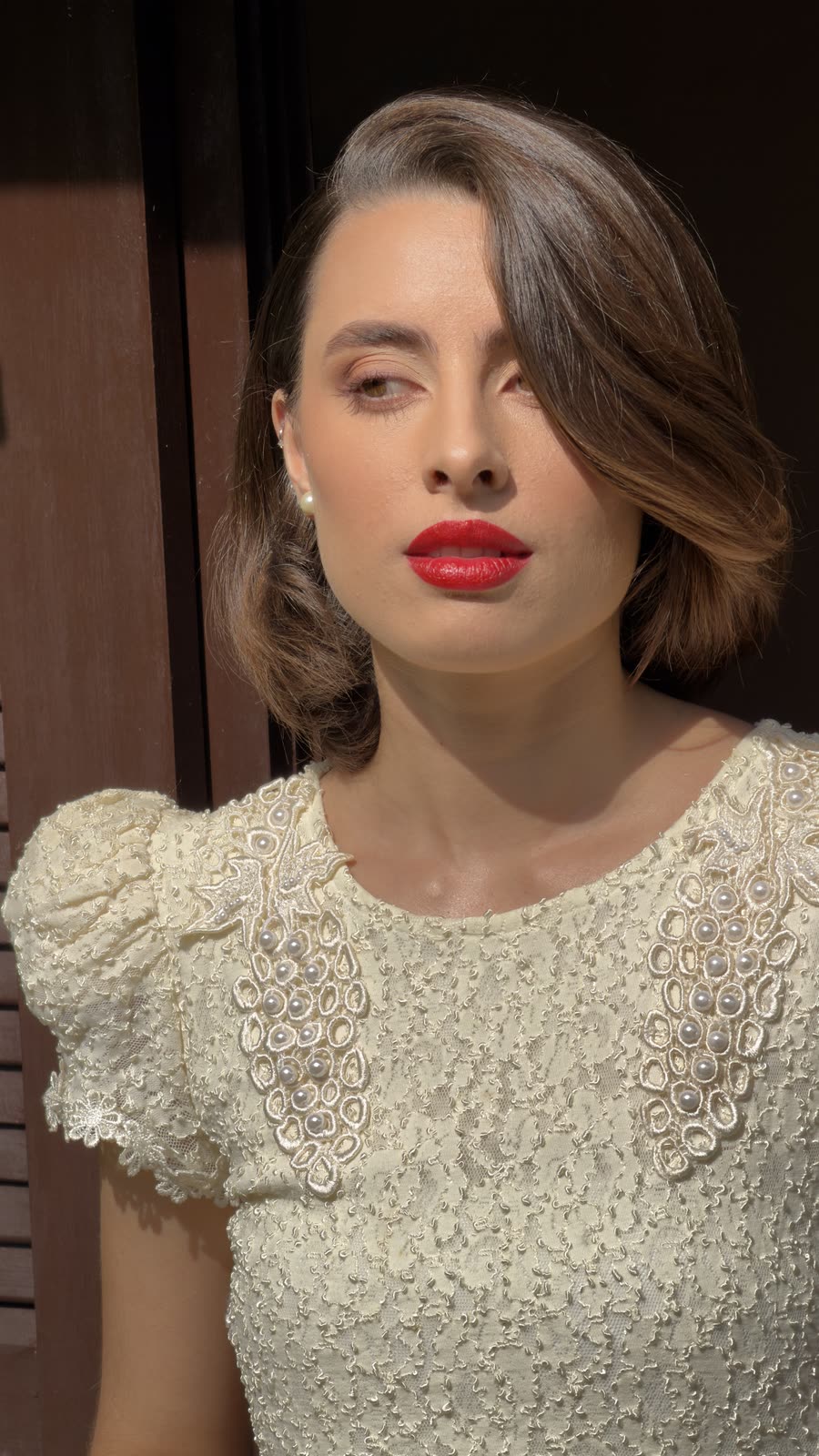 Close do rosto da noiva, batom vermelho e olhar para a câmera