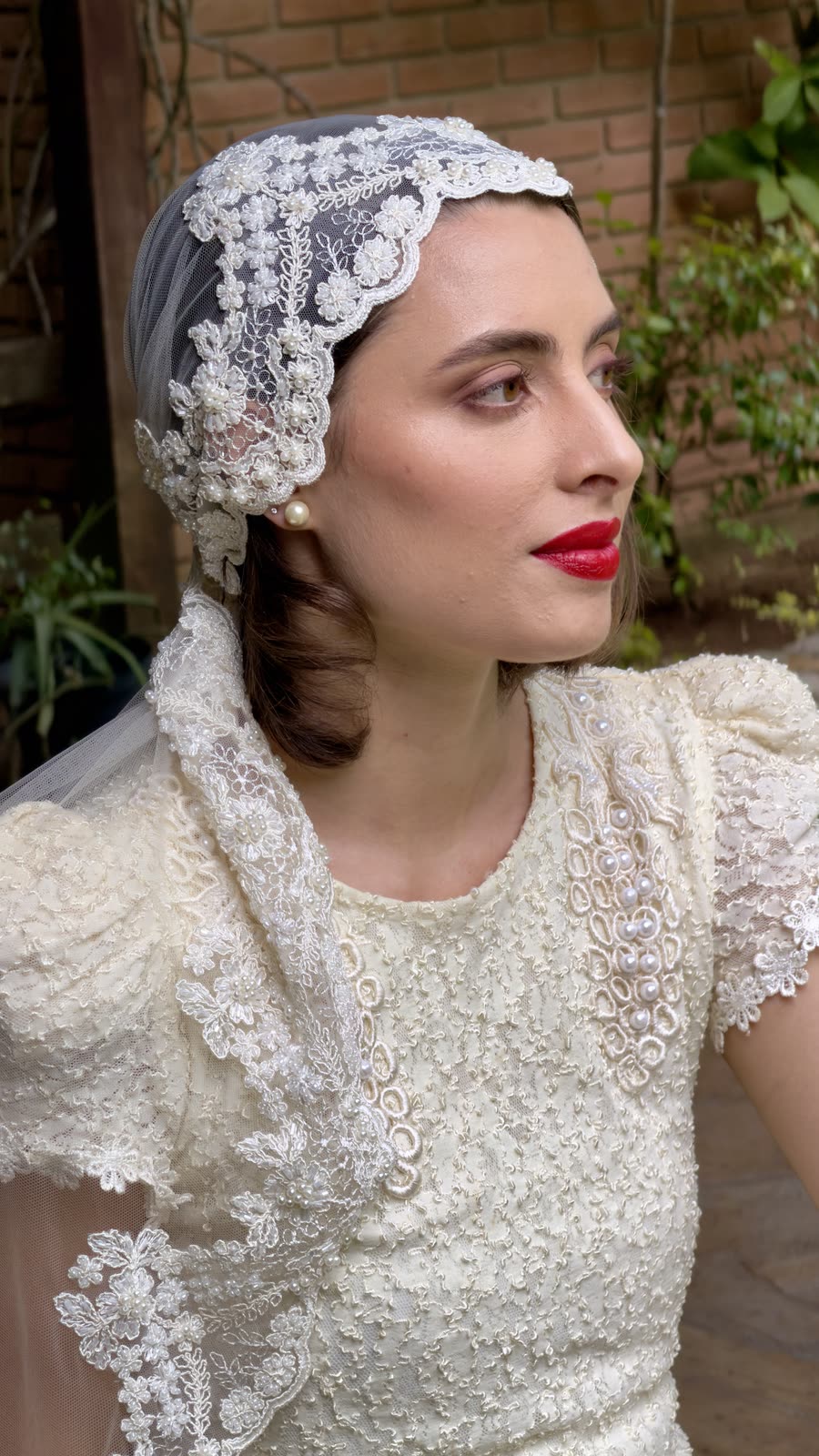 Perfil da noiva com touca de renda sobre o cabelo ondulado